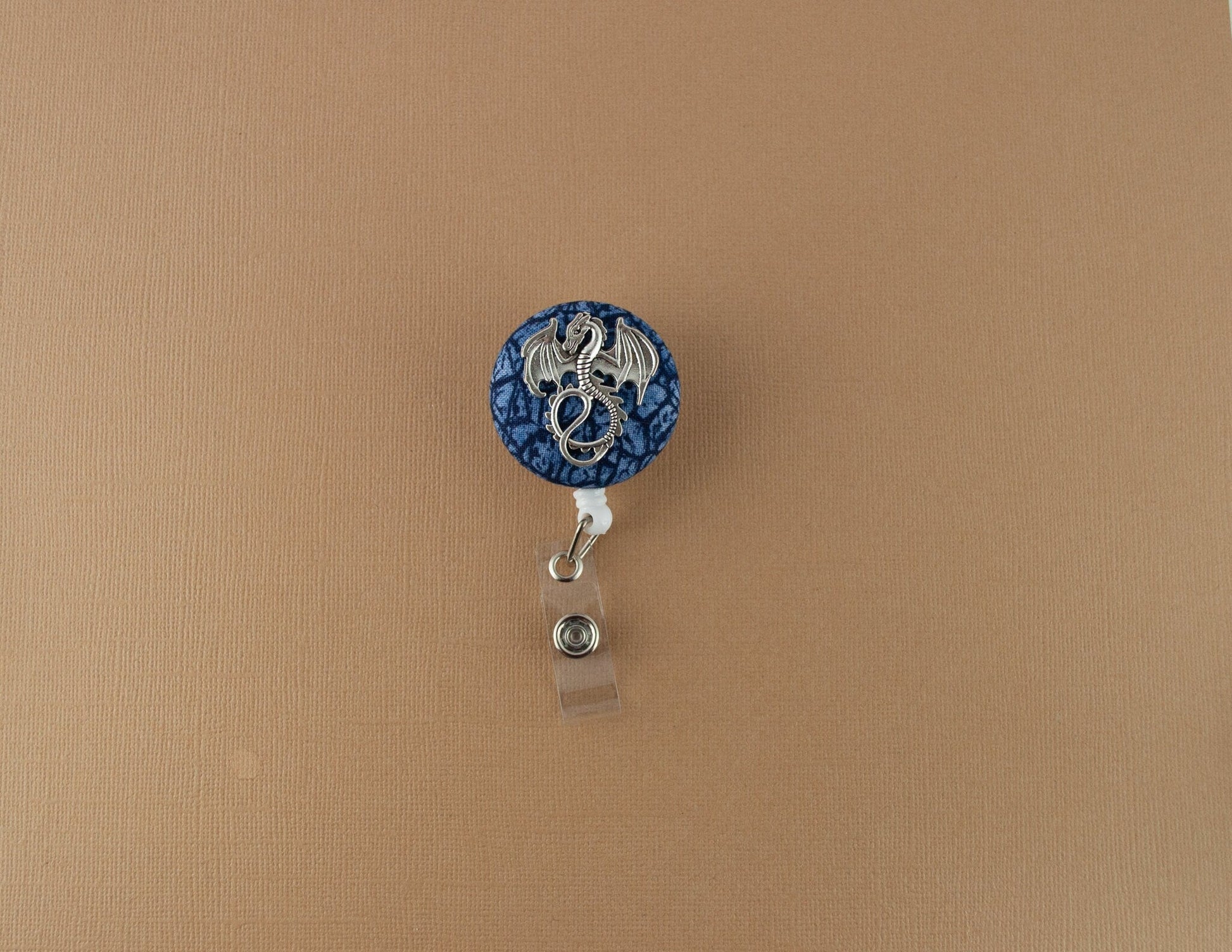 Silver dragon on blue scales badge reel - Rowan Gate