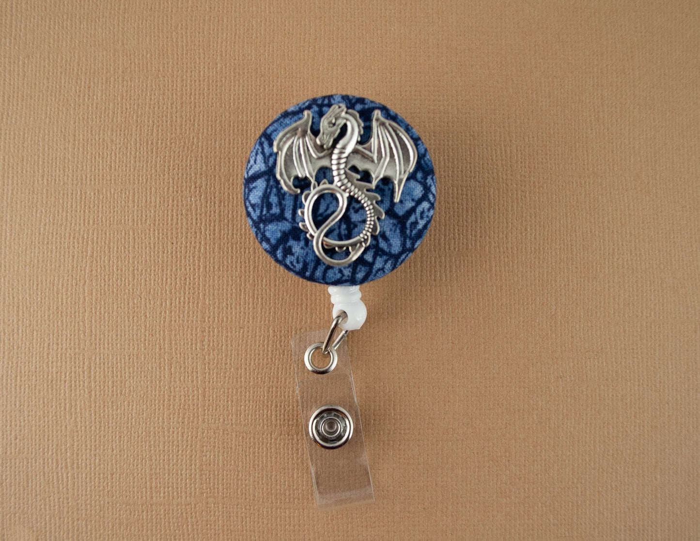 Silver dragon on blue scales badge reel - Rowan Gate